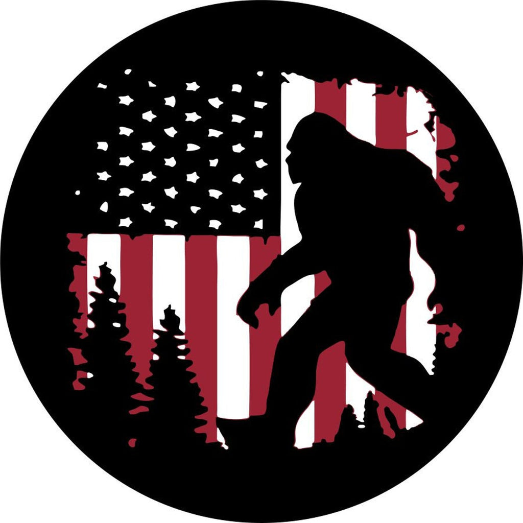 spare tire cover design has Bigfoot walking through the forest with a rustic old glory, the American flag, as the background.