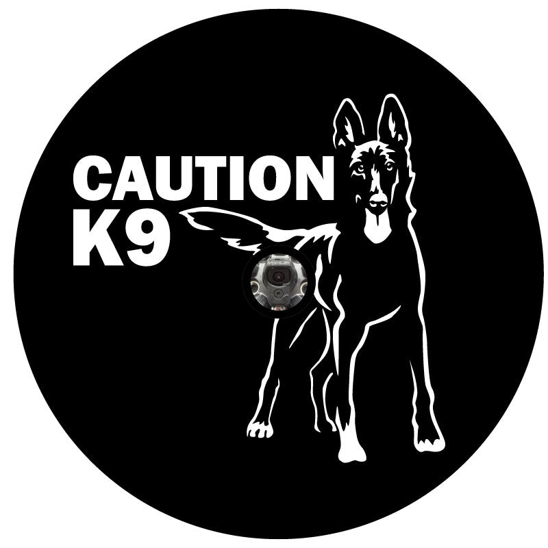 Silhouette of a Belgian Malinois and the words caution K9 spare tire cover design for Jeep, Bronco, RV, camper, trailer, and more on black vinyl with back up camera