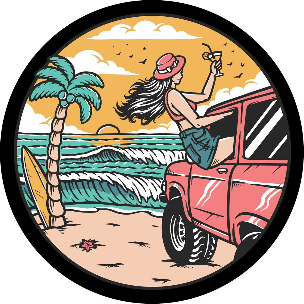 Spare tire cover design of a girl at the beach sitting out the window of a coral colored or pink Bronco with a drink in hand watching the sunset and waves crash along the shoreline.