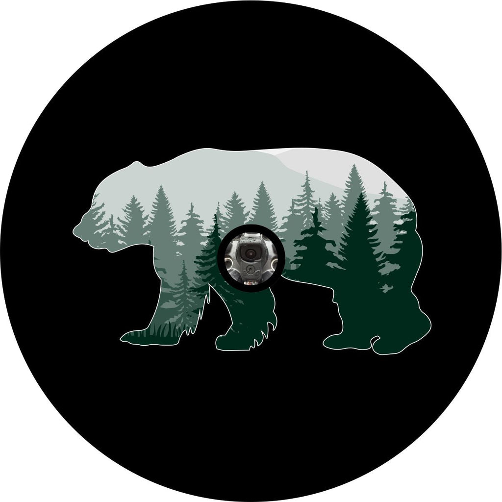 Green ombre style forest line silhouette inside the silhouette of a bear spare tire cover on black vinyl with a camera hole design