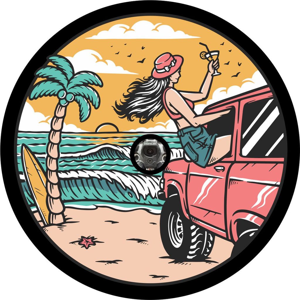 Back up camera spare tire cover design of a girl at the beach sitting out the window of a coral colored or pink Bronco with a drink in hand watching the sunset and waves crash along the shoreline.
