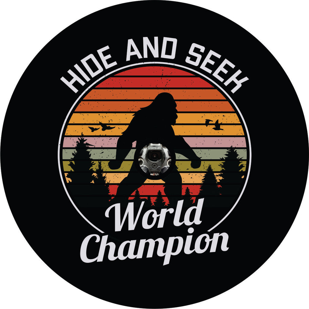 Unique spare tire cover. Bigfoot tire cover. Sasquatch walking in the woods and hide and seek world champion written along the spare tire cover. Spare tire cover for Jeep, Bronco, RV, camper, and more. Accommodates a Jeep tire cover with camera hole