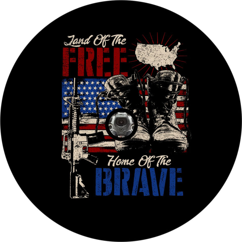 Patriotic spare tire cover design with images of a military rifle, boots, and a silhouette of the United States on top of an American flag and the quote, "land of the free home of the brave" with space with a back up camera
