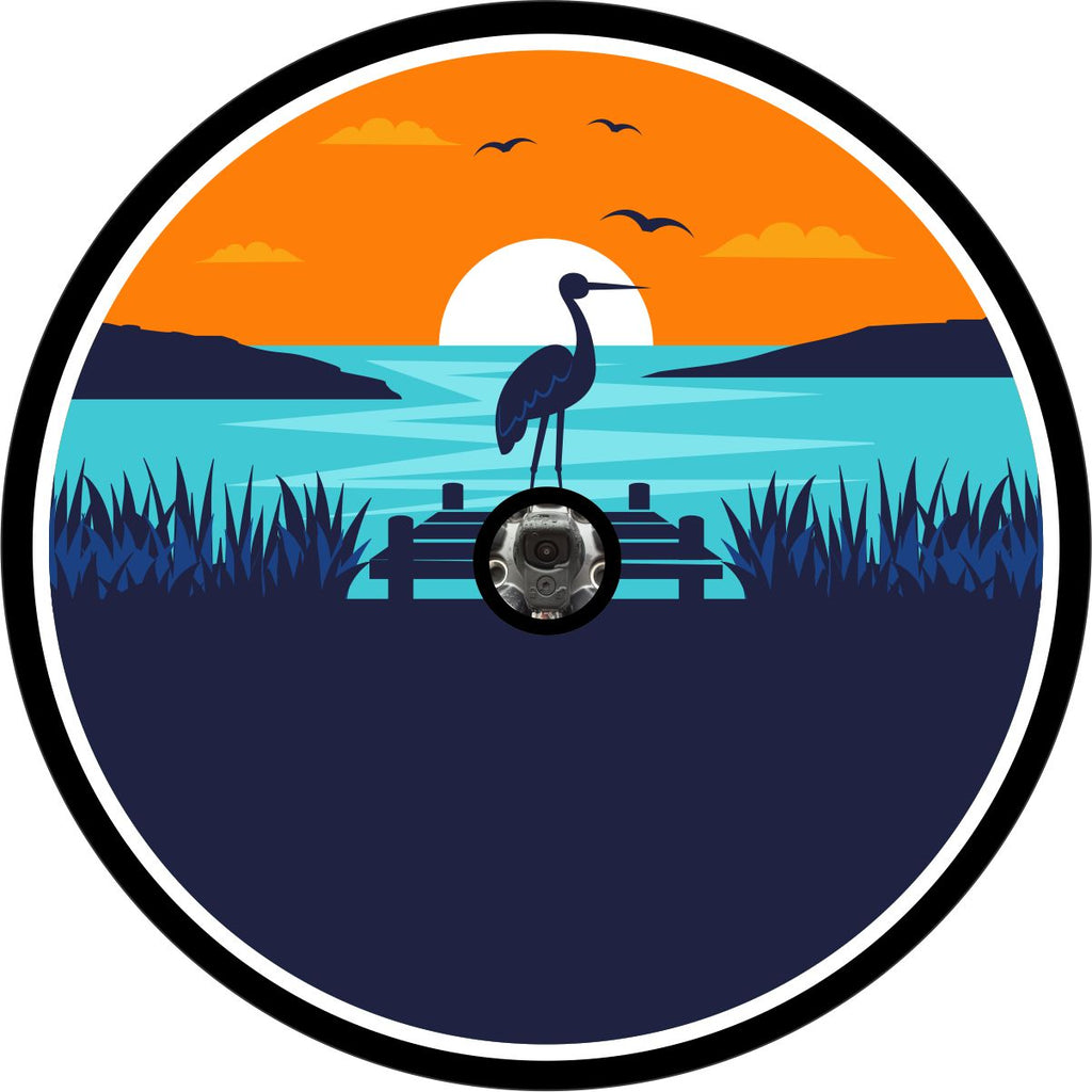 Picturesque scene of a coastal landscape with a sea bird or heron sitting near a dock with the sunsetting with layout for camera hole