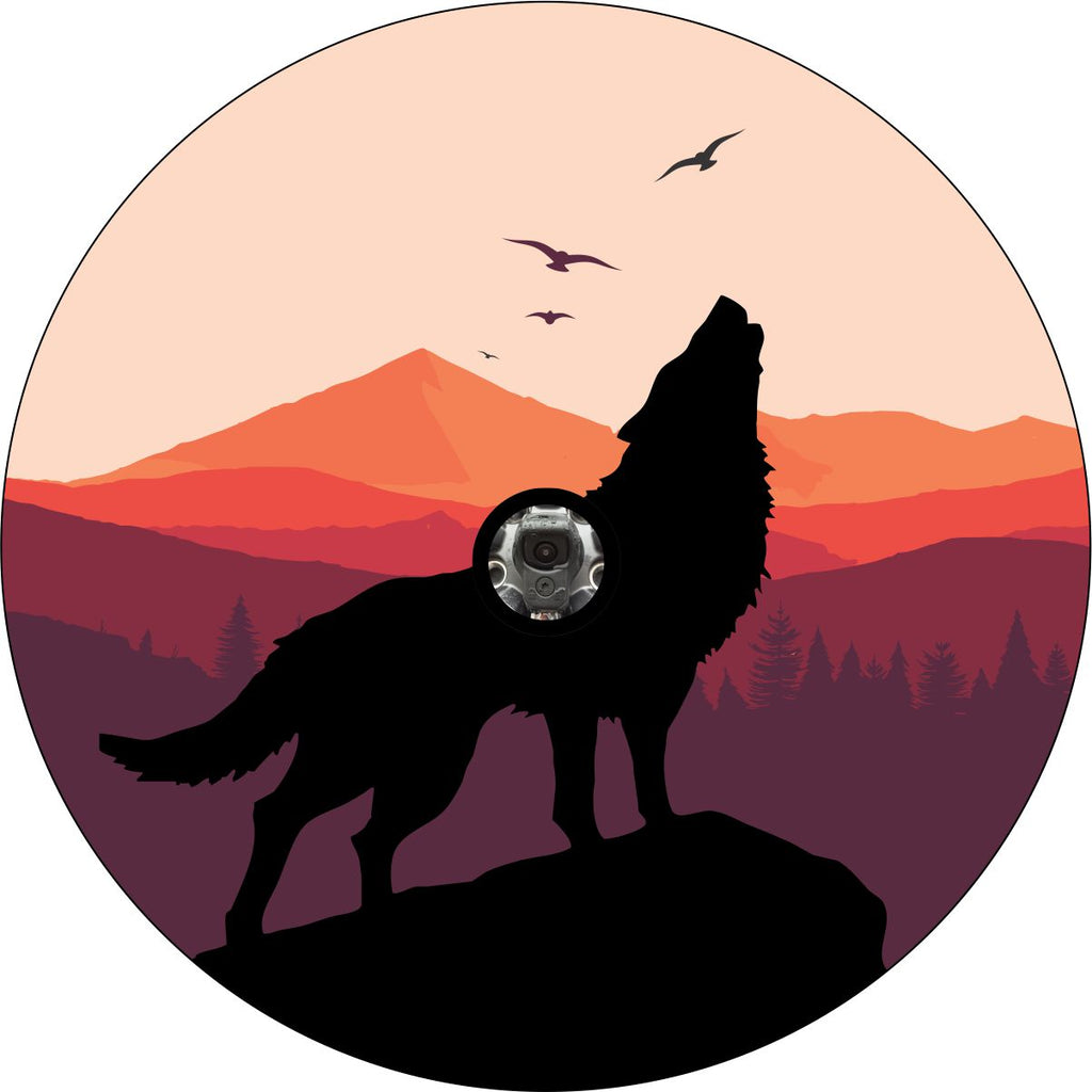 Wolf silhouette howling on a mountain top with sunset colors and mountains in the background spare tire cover for Jeep, RV, Bronco, campers, and more with a back up camera.