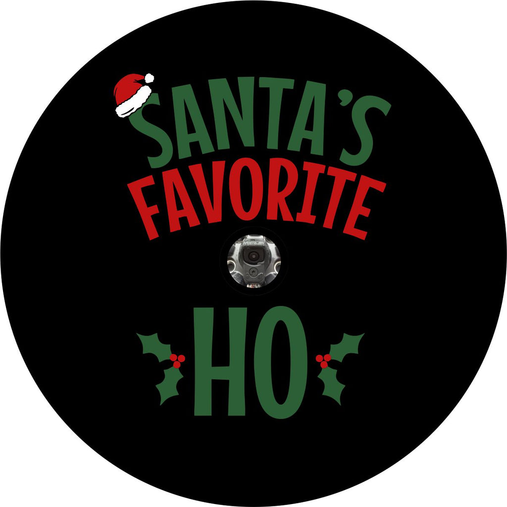 Black vinyl funny spare tire cover design in green and red letters saying Santa's Favorite Ho, with a Santa hat and holly berries Christmas theme design. Spare tire cover design for back up cameras on Jeep, Bronco, Campers, and more