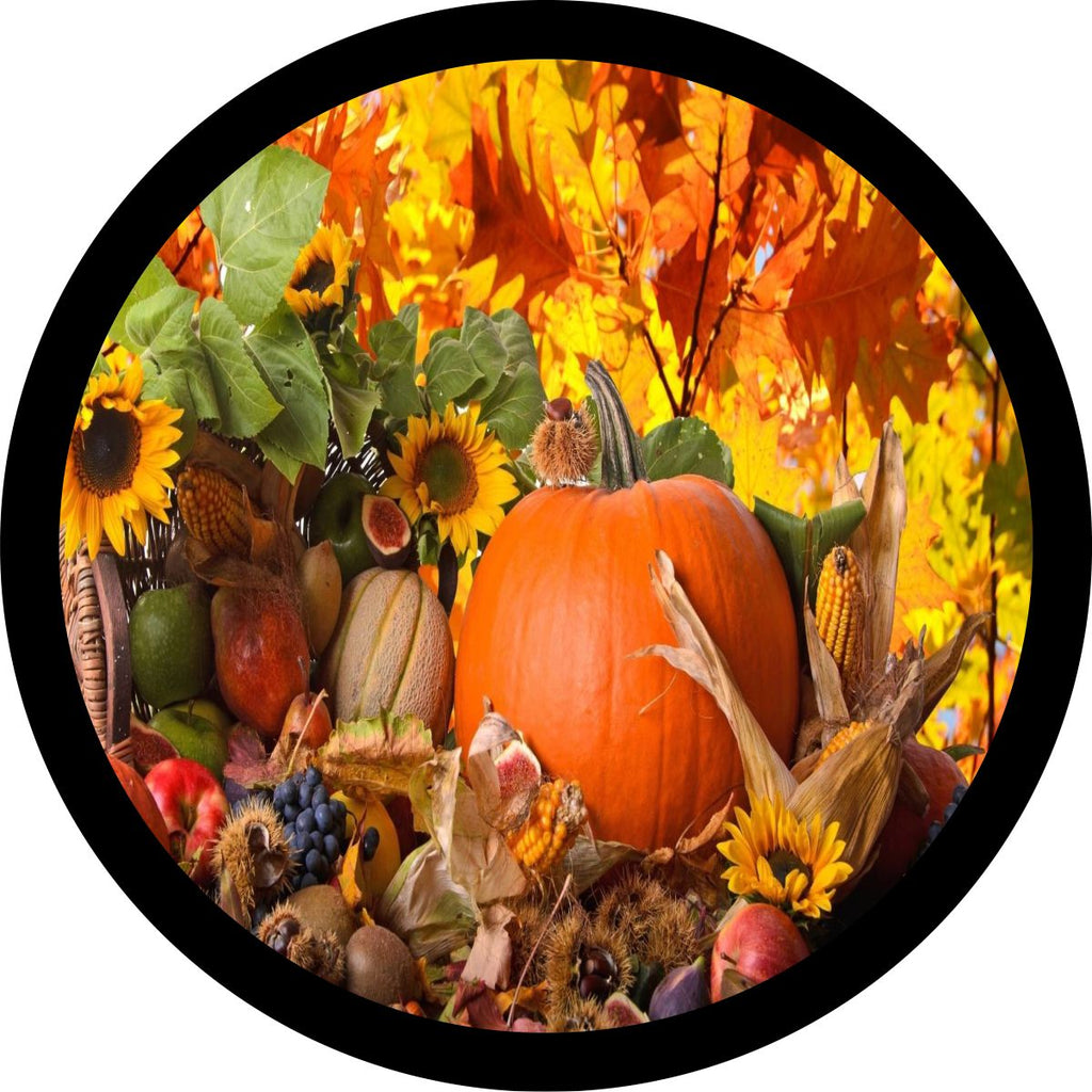 A spare tire cover with an image of a pumpkin, gourds, apples, sunflowers, and fall leaves.