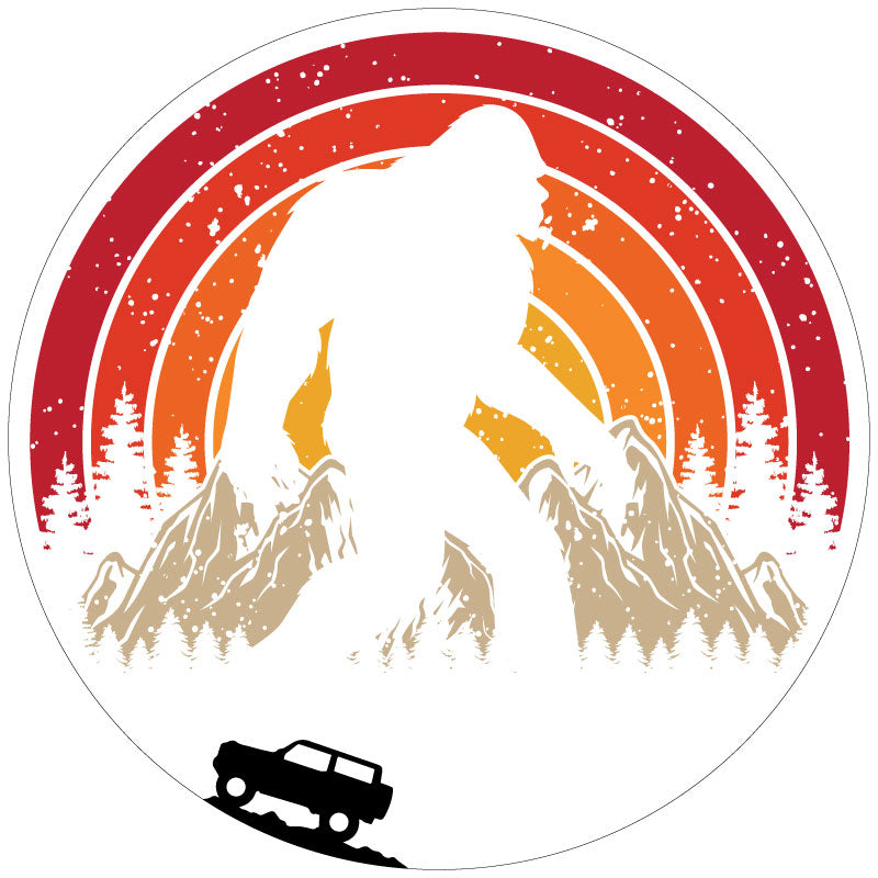 A retro vintage spare tire cover design with Sasquatch or bigfoot walking through the mountains and the silhouette of a Ford Bronco driving.  Designed for a white vinyl spare tire cover